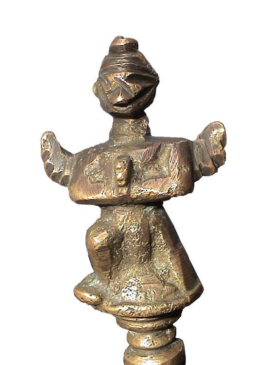 The mystery deepens because while the figurine has elements of a human, it also posses elements that are suggestive of a winged creature or bird. Figurine on the bell handle - front view.