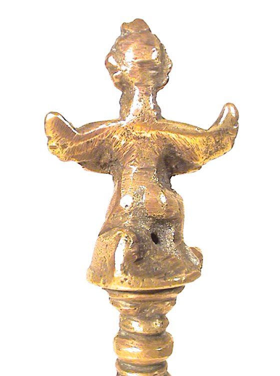 A study of the figurine can provide us with insights as to the purpose of the object and who actually made the object. Rear view of the figurine on the handle of the bronze bell.