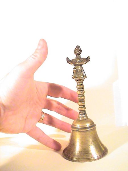 Of course, when something as remarkable as this tiny hand-bell falls out of a chunk of coal, it is saved and treasured. The mysterious bell with hand to show comparative sizes.