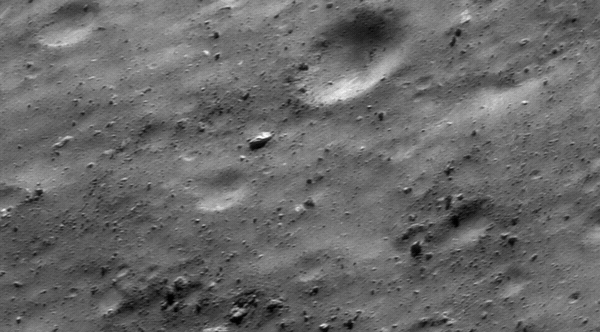 This view of asteroid 433 Eros is part of an image mosaic taken in the early hours of October 26, 2000, during NEAR Shoemaker's low-altitude flyover of Eros. Taken while the spacecraft's digital camera was looking at a spot 8 kilometers (5 miles) away, the image covers a region about 800 meters (2600 feet) across. Rocks of all sizes and shapes are set on a gently rolling, cratered surface. Locally, fine debris or regolith buries the rocks. The large boulder at the center of the scene is about 25 meters (82 feet) across.